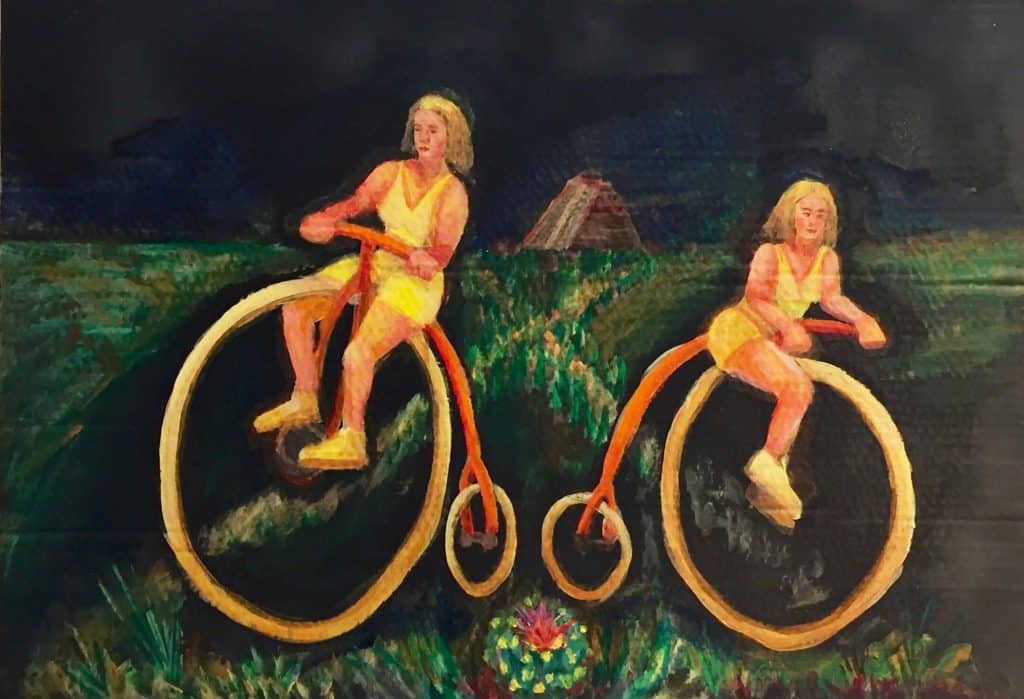 two women on penny farthing bikes in a field